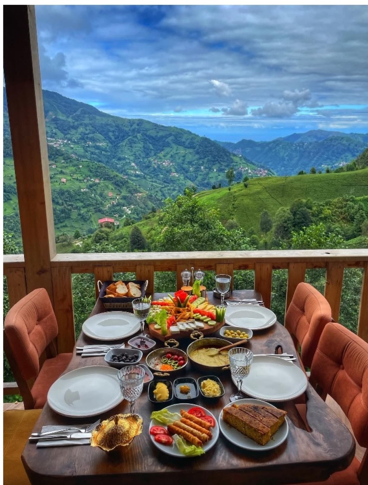 Breakfast laid out on a balcony above green hills